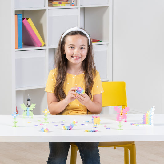240 pc Pastel tube: girl building pastel builds at a playroom table