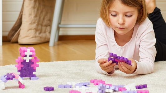 child playing with Plus-Plus on a rug