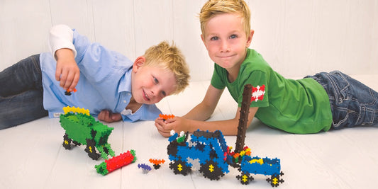 two kids playing with Plus-Plus toys