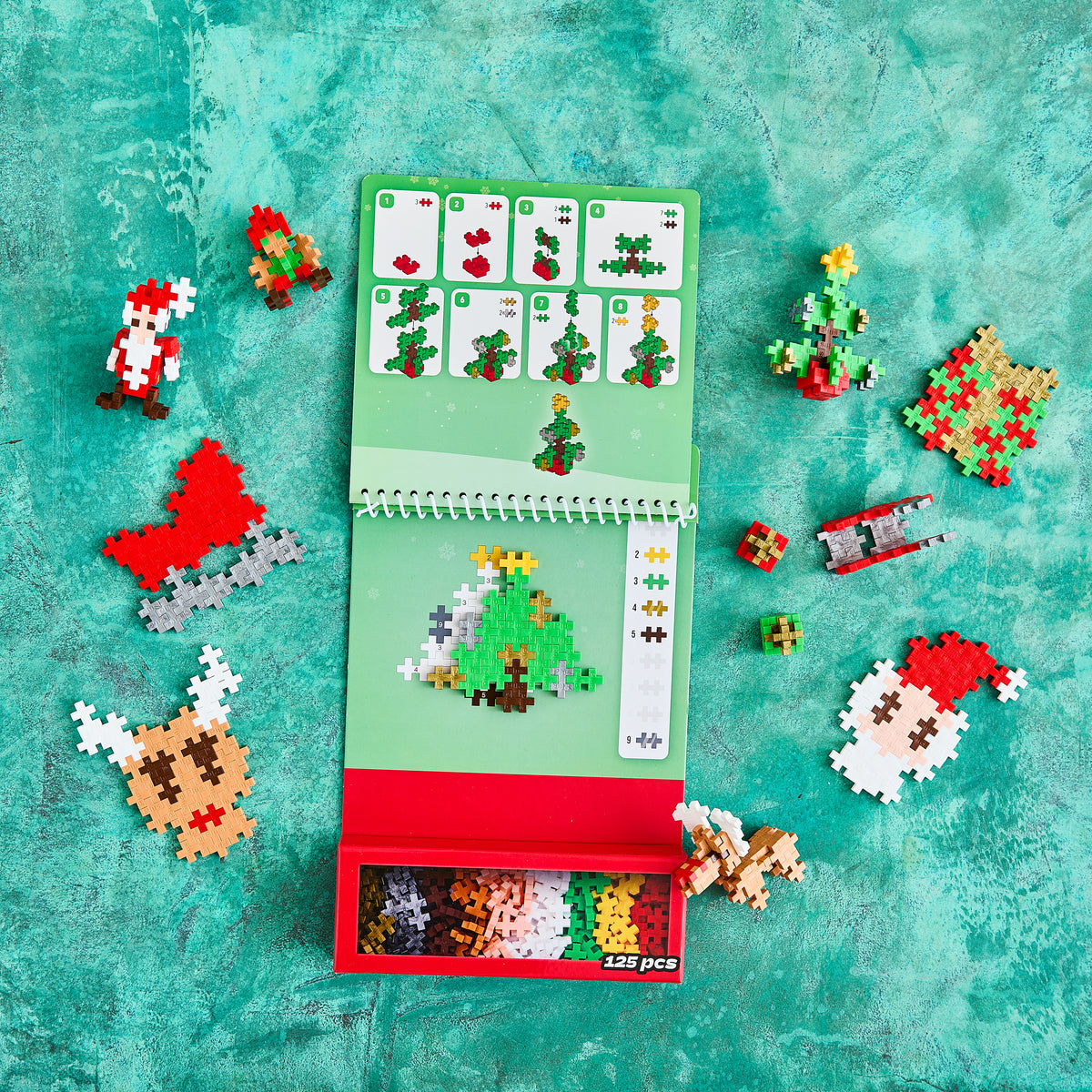 Holiday Activity Pad with Christmas tree, Santa, reindeer and sleigh builds on teal