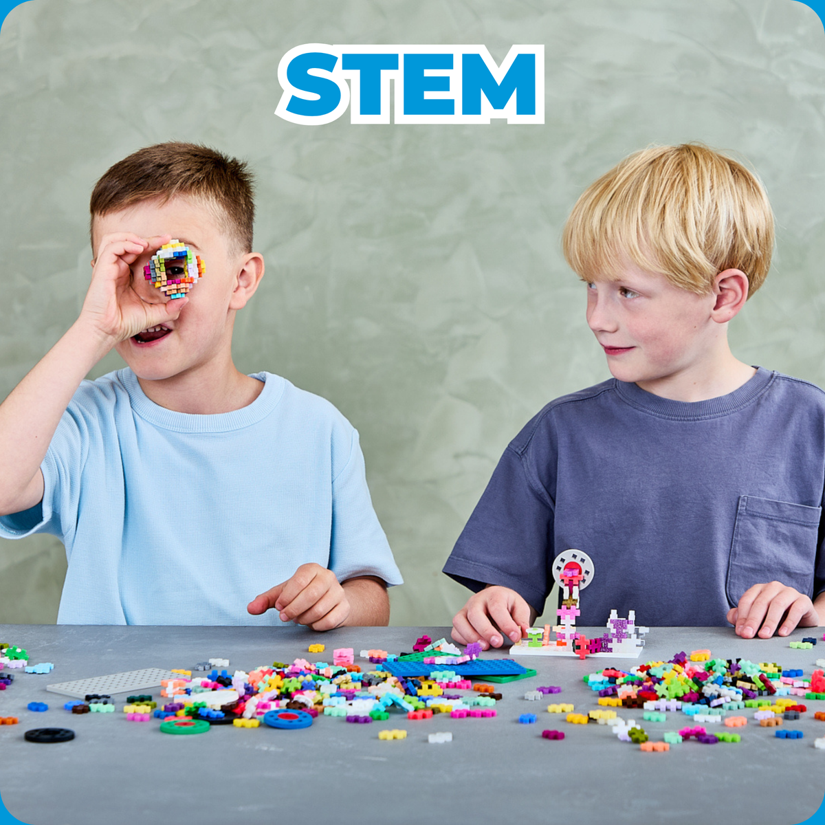Shop by Theme - STEM: two boys building with Plus-Plus, one looking through a build