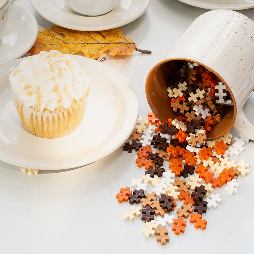 Tube - 240 pc - Pumpkin Spice Mix: tube spilling fall colored pieces beside a cupcake